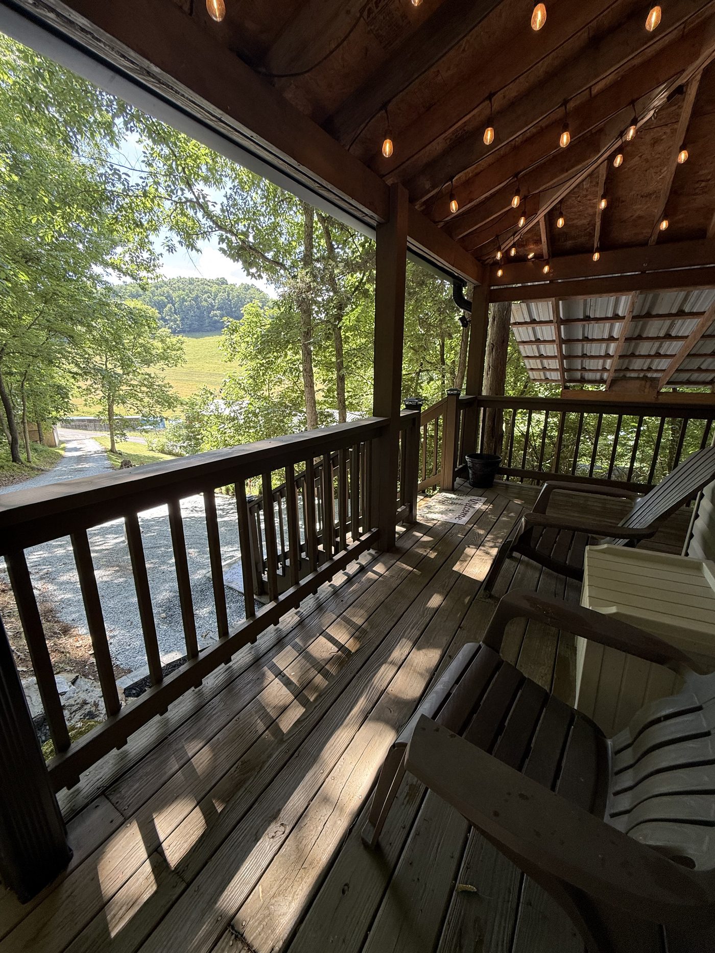 Covered porch with string lights and forest view