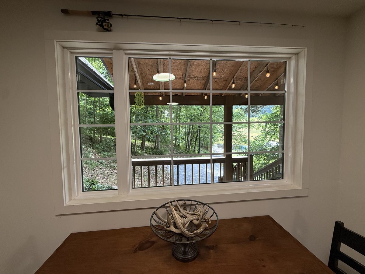View to covered porch and woods from dining area